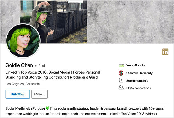Esta es una captura de pantalla del perfil de LinkedIn de Goldie Chan. Ella es una mujer asiática con cabello verde. En su foto de perfil, lleva maquillaje, una gargantilla negra y una camisa negra. Su lema dice “LinkedIn Top Voice 2018: Social Media | Colaborador de Forbes Personal Branding y Storytelling | Gremio de productores "