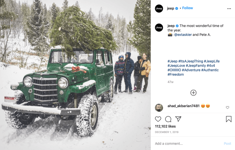 Publicación de instagram de @jeep que muestra a una familia al final de la caza de árboles de Navidad con un árbol en la parte superior de su jeep, en lo profundo de la nieve y el campo de árboles.