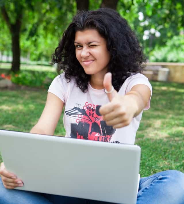 Chica en la computadora portátil en el parque