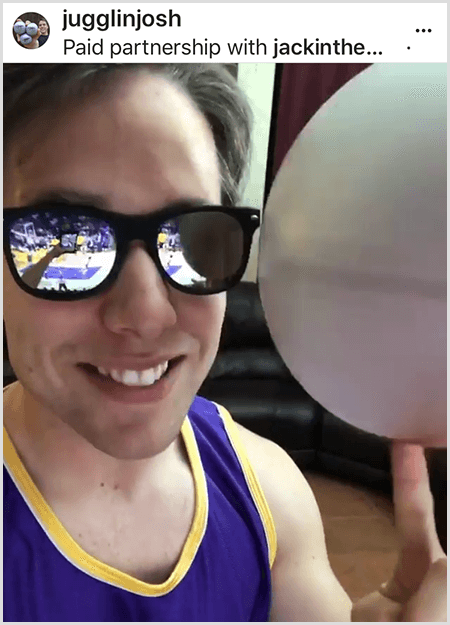 Josh Horton publica una foto para una campaña con Jack in the Box y los LA Lakers. Josh usa lentes de sol espejados y una camiseta de los Lakers y sonríe para la cámara mientras hace girar una pelota.