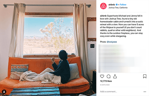 Esta es una captura de pantalla de una publicación de Instagram de Airbnb. Cuenta la historia de una pareja que recibe a personas en su casa a través de Airbnb. En la foto, alguien se sienta en un sofá naranja debajo de una manta de punto beige y mira por la ventana un paisaje desértico. Melissa Cassera dice que estas historias son un ejemplo de una empresa que utiliza la trama de la superación del monstruo en su marketing de redes sociales.